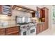 Gourmet kitchen featuring a Wolf range, custom cabinets, granite countertops, and tiled backsplash at 7841 E Stonecliff Cir, Mesa, AZ 85207
