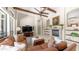 Living room featuring fireplace, wood beam ceilings, fan, and views to windows overlooking the backyard at 7841 E Stonecliff Cir, Mesa, AZ 85207