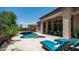 Backyard features a pool with waterfall feature, lounge chairs, and covered patio at 7841 E Stonecliff Cir, Mesa, AZ 85207