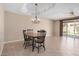 Dining room featuring an open layout, tile floors, a chandelier and access to a patio at 8874 W Piute Ave, Peoria, AZ 85382