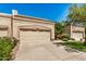 Beige home exterior featuring a garage with beige doors and well-manicured landscaping at 8874 W Piute Ave, Peoria, AZ 85382