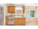 Kitchen featuring wood cabinets, tile floors, a small window, and stainless steel appliances at 8874 W Piute Ave, Peoria, AZ 85382