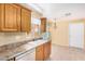 Charming kitchen featuring wood cabinets, tiled floors, and a double basin sink at 8874 W Piute Ave, Peoria, AZ 85382