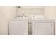 Clean laundry room with a white washer and dryer set, complete with overhead shelving for storage at 8874 W Piute Ave, Peoria, AZ 85382