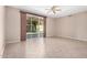 An empty living room with tile floors, a ceiling fan, and sliding glass doors at 8874 W Piute Ave, Peoria, AZ 85382