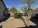 Backyard featuring low-maintenance desert landscaping and outdoor dining area with lush trees creating a private retreat at 8927 W Paradise Dr, Peoria, AZ 85345