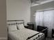 Bedroom with a black metal frame bed, desk, and bright natural light at 8927 W Paradise Dr, Peoria, AZ 85345