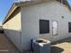 Corner view showing stucco siding and roof detail with small windows, and an AC unit at 8927 W Paradise Dr, Peoria, AZ 85345