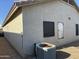 Corner view showing stucco siding and roof detail with small windows, and an AC unit at 8927 W Paradise Dr, Peoria, AZ 85345