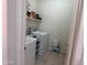 Bright laundry room with modern washer and dryer, equipped with shelving for storage at 8927 W Paradise Dr, Peoria, AZ 85345