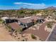 Aerial view of a custom home with lush landscaping, multiple garages, and a circular driveway at 9456 E Sands Dr, Scottsdale, AZ 85255