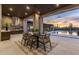 Outdoor dining area features a table with seating for six, perfect for enjoying meals overlooking the pool and desert views at 9456 E Sands Dr, Scottsdale, AZ 85255
