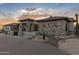 Stunning stone-clad exterior with desert landscaping and a paver driveway, showcasing elegant design and curb appeal at 9456 E Sands Dr, Scottsdale, AZ 85255