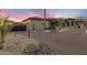 Beautiful exterior of a desert home with a paver driveway, xeriscaping, and a gated entrance at 9456 E Sands Dr, Scottsdale, AZ 85255