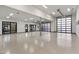 Large garage with epoxy flooring, bright lighting, and glass panel doors with access to an outdoor gym at 9456 E Sands Dr, Scottsdale, AZ 85255