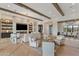 Bright and open living room with wood floors, beamed ceilings, a fireplace, and comfortable seating at 9456 E Sands Dr, Scottsdale, AZ 85255