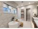 An elegant main bathroom featuring soaking tub, picture window and marble walls at 9456 E Sands Dr, Scottsdale, AZ 85255