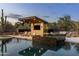 Relaxing outdoor lounge area with tv and comfortable seating, complemented by a sparkling pool and desert vista at 9456 E Sands Dr, Scottsdale, AZ 85255