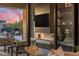 Stylish outdoor living area with fireplace, TV, and sunset view at 9456 E Sands Dr, Scottsdale, AZ 85255