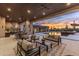 Expansive covered patio boasts comfortable seating, dining area, and outdoor kitchen overlooking the sparkling pool and desert landscape at 9456 E Sands Dr, Scottsdale, AZ 85255