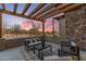 Inviting outdoor patio area with comfortable seating, a wooden pergola, and desert landscape at 9456 E Sands Dr, Scottsdale, AZ 85255