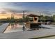 Luxury pool with integrated lounge area offers a tranquil retreat amidst the desert scenery and stunning sunset backdrop at 9456 E Sands Dr, Scottsdale, AZ 85255