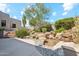 Landscaped backyard featuring a serene pond, lush greenery, and rock formations at 10040 E Happy Valley Rd # 243, Scottsdale, AZ 85255