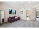 Spacious, carpeted bedroom with a purple sofa, a tall mirror, and bright natural light from outside at 10040 E Happy Valley Rd # 243, Scottsdale, AZ 85255