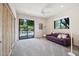 Light-filled bedroom featuring a sliding door to a pool, carpet, ceiling fan and purple couch at 10040 E Happy Valley Rd # 243, Scottsdale, AZ 85255