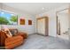 Bright bedroom with a cozy orange couch, a large window, and a decorative wooden cabinet at 10040 E Happy Valley Rd # 243, Scottsdale, AZ 85255