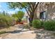 Landscaped exterior showing stone patio and native desert vegetation and a glimpse of the house's architecture at 10040 E Happy Valley Rd # 243, Scottsdale, AZ 85255