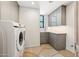 Functional laundry room with modern appliances, ample cabinet storage, and a window for natural light at 10040 E Happy Valley Rd # 243, Scottsdale, AZ 85255