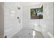 This walk-in shower features white tiling, a glass door, a shower seat, and a bright window at 10040 E Happy Valley Rd # 243, Scottsdale, AZ 85255