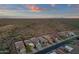 An aerial view displays a sprawling desert landscape with rows of well-maintained homes in the distance at 10775 E Peralta Canyon Dr, Gold Canyon, AZ 85118