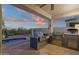 Outdoor kitchen featuring stainless steel grill, smoker, and nearby pool at 10775 E Peralta Canyon Dr, Gold Canyon, AZ 85118