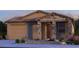 Charming single-story home with stone accents, a tile roof, and a two-car garage in a desert landscape at 10859 E Tillman Ave, Mesa, AZ 85212