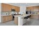 Bright kitchen featuring stainless steel appliances, an island with barstools, wooden cabinets, and sleek countertops at 10860 E Tiburon Ave, Mesa, AZ 85212