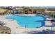 Community pool with lounge chairs and umbrellas and ample seating around the large community pool at 10905 E Texas Ave, Mesa, AZ 85212