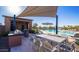 Outdoor grilling area with a built-in grill, shaded dining table, and a view of the community pool at 10905 E Texas Ave, Mesa, AZ 85212