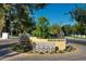 Inviting community entrance with decorative brick sign and mature trees welcomes you to Woodlea Melrose at 1117 W Glenrosa Ave, Phoenix, AZ 85013