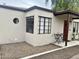 Unique house exterior with dark framed windows, red door, and small seating area at 1117 W Glenrosa Ave, Phoenix, AZ 85013