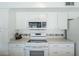 All-white kitchen boasts built-in microwave, modern appliances, and generous counter space at 11631 N 30Th St, Phoenix, AZ 85028