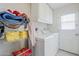 Laundry room with side by side white washer and dryer, cabinets, shelving and an exterior door at 11631 N 30Th St, Phoenix, AZ 85028