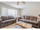 Cozy living room with a large window, ceiling fan, comfortable couches, and neutral color scheme at 11631 N 30Th St, Phoenix, AZ 85028