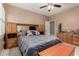 Cozy bedroom with storage headboard, fan, and mounted television at 1268 N Pine St, Gilbert, AZ 85233