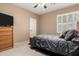 Relaxing bedroom featuring a ceiling fan, dresser, and window with plantation shutters at 1268 N Pine St, Gilbert, AZ 85233