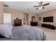 Main bedroom featuring plush carpet, ceiling fan, tv, and access to the main bathroom at 1268 N Pine St, Gilbert, AZ 85233