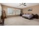 Bright main bedroom featuring plush carpet, ceiling fan, and plantation shutters at 1268 N Pine St, Gilbert, AZ 85233