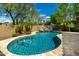 Sparkling pool with rock waterfall feature surrounded by well-maintained landscaping creates a serene backyard oasis at 1268 N Pine St, Gilbert, AZ 85233