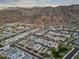An expansive aerial view reveals a community of modern homes nestled near mountain scenery and a distant city at 1337 E Paseo Way, Phoenix, AZ 85042